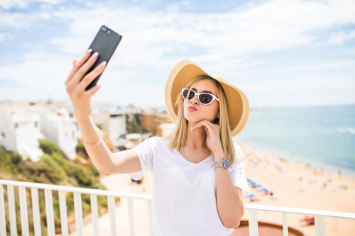 influencer taking a summer photo by the beach