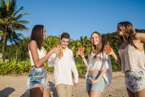 seasonal themes plam trees beach group of friends sharing a drink together